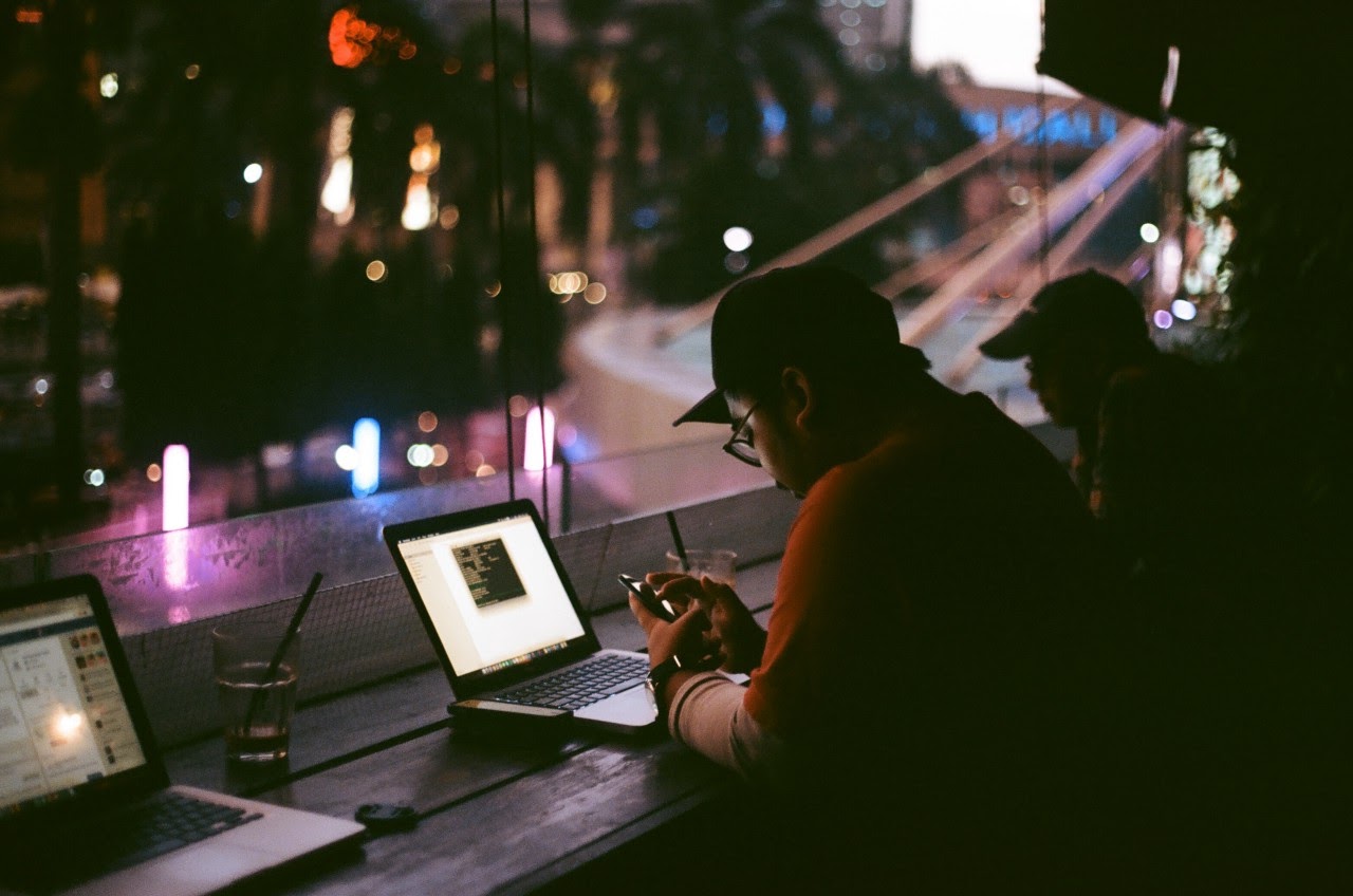 Laptop users in a cafe at night-time